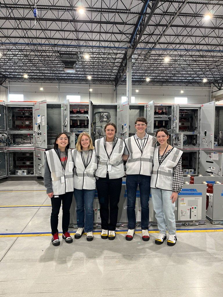 Team in safety vests on a factory floor
